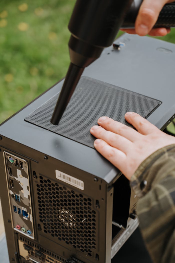 digital Person cleaning PC case with an electric duster to prevent dust buildup and ensure efficient airflow.